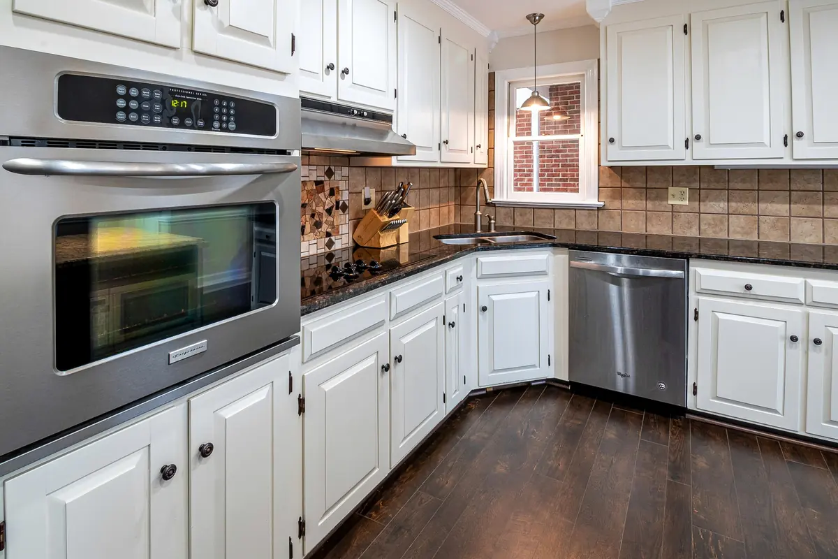 Cocina remodelada con muebles blancos y encimera