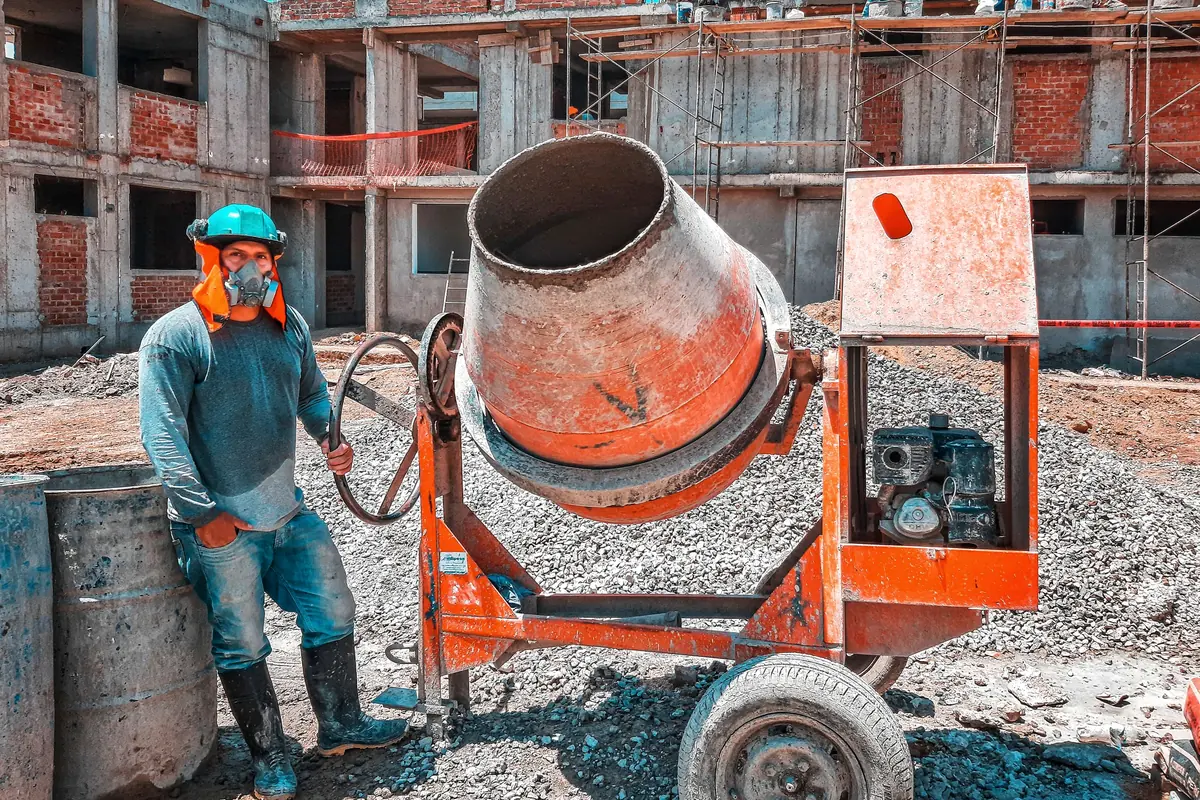 Maestro operando una betonera en obra gruesa